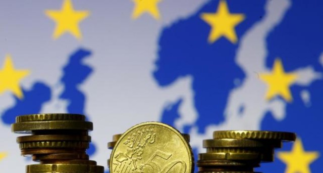 Euro coins are seen in front of displayed flag and map of European Union in this picture illustration taken in Zenica